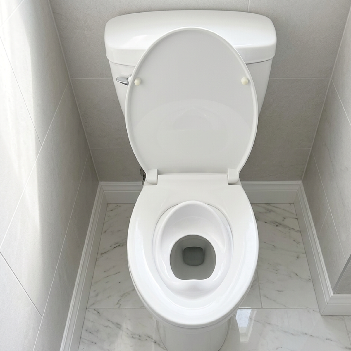 Tot Perch toddler toilet seat insert — bird's eye view, toilet lid closed over and locking it in place